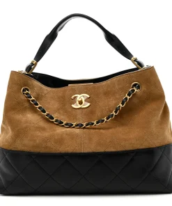 Beige Chanel quilted suede tote featuring black leather accents and gold CC turn lock closure