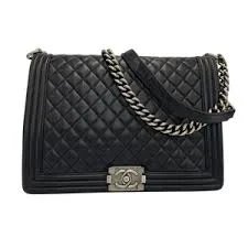 Close-up of Chanel Boy bag CC push lock and metal hardware and silver strap detail