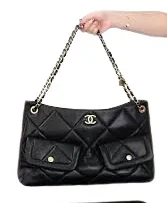 Close-up of Chanel Maxi Hobo Bag featuring black quilted leather and gold-tone metal accents