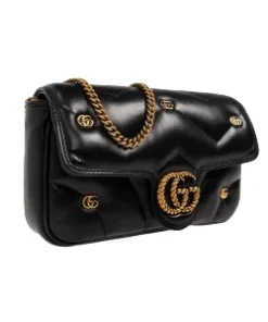 Side view of black Gucci GG Marmont small shoulder bag with antique gold chain strap