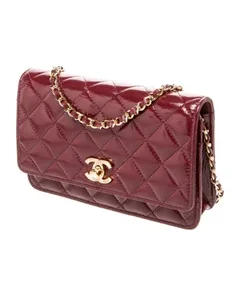 mahroon patent leather Chanel wallet displayed on branded box