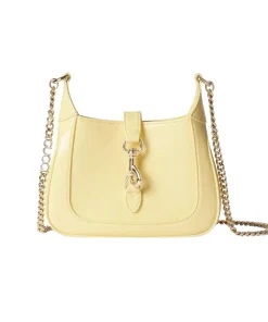 Pastel yellow mini hobo shoulder bag in glossy patent leather with gold chain strap and front clasp detail on a clean white background