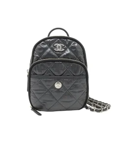 Black side angle view of Chanel Coco Neige backpack highlighting compact shape and premium designer silhouette