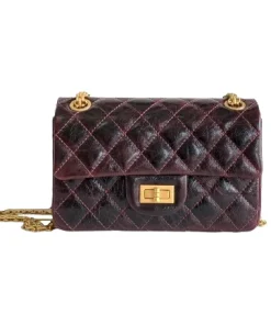 Chanel mini reissue 2.55 bag worn as crossbody with elegant gold hardware