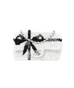 Chanel white sequin mini flap bag with black bow design and silver hardware chain strap