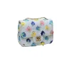 Stylish white crossbody bag featuring multicolor floral appliqué and gold hardware for summer fashion