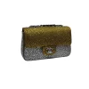 Side view of gold and silver rhinestone Chanel mini flap bag with chain strap and sparkling crystal detailing
