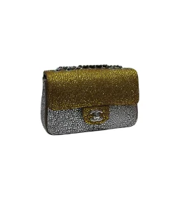 Side view of gold and silver rhinestone Chanel mini flap bag with chain strap and sparkling crystal detailing