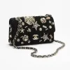 Luxury Chanel mini classic handbag in black velvet with crystal and pearl detailing and gold accents for evening wear