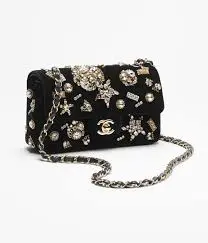 Luxury Chanel mini classic handbag in black velvet with crystal and pearl detailing and gold accents for evening wear