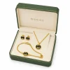 Gold Gucci jewelry set with necklace, earrings, and bracelet featuring black enamel interlocking G logos