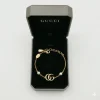 Gold Gucci GG Marmont bracelet with Double G logo and white glass pearl chain details