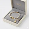 Gold Christian Dior 30 Montaigne bracelet with white resin pearls and CD charm