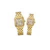 A pair of luxury Yellow Gold Panthère de Cartier style watches with diamond-set dials held in a gloved hand.