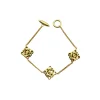 Gold-tone Loewe Anagram charm bracelet displayed inside a luxury cream jewelry box on a white background