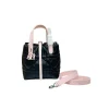 light pink and black quilted Dior Toujours tote bag with black leather accents displayed on a modern table.